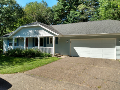 Light blue ranch style house with white garage