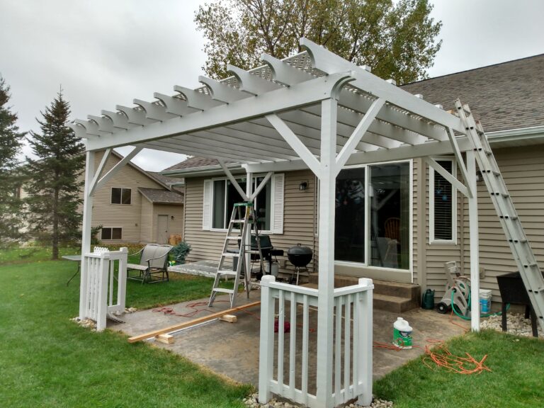 Pergola over patio with ladders extending painter's reach