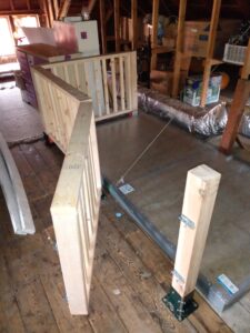 railing with an open gate next to horizontal attic door.